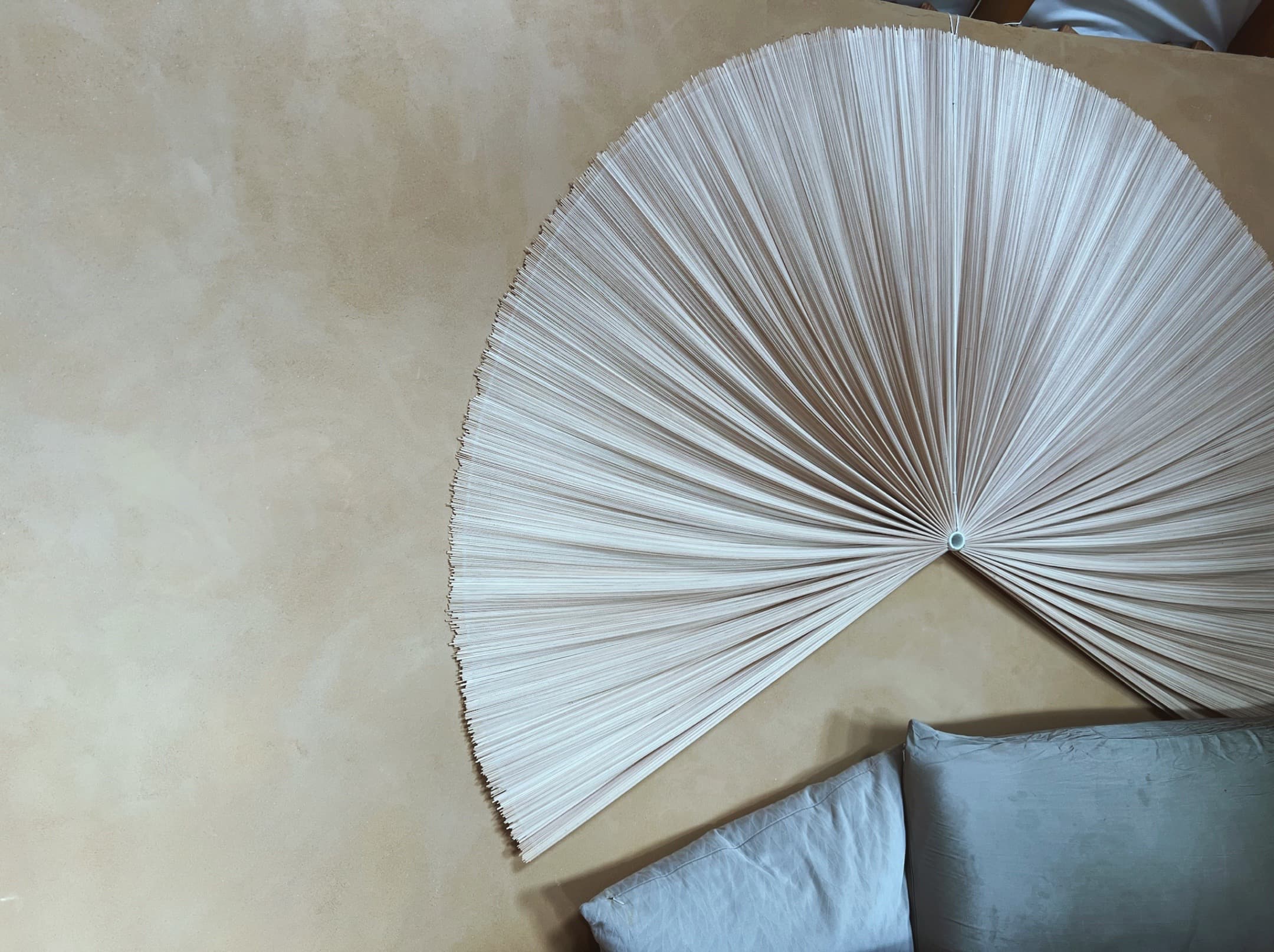 Bedroom with clay plaster walls and decorative fan